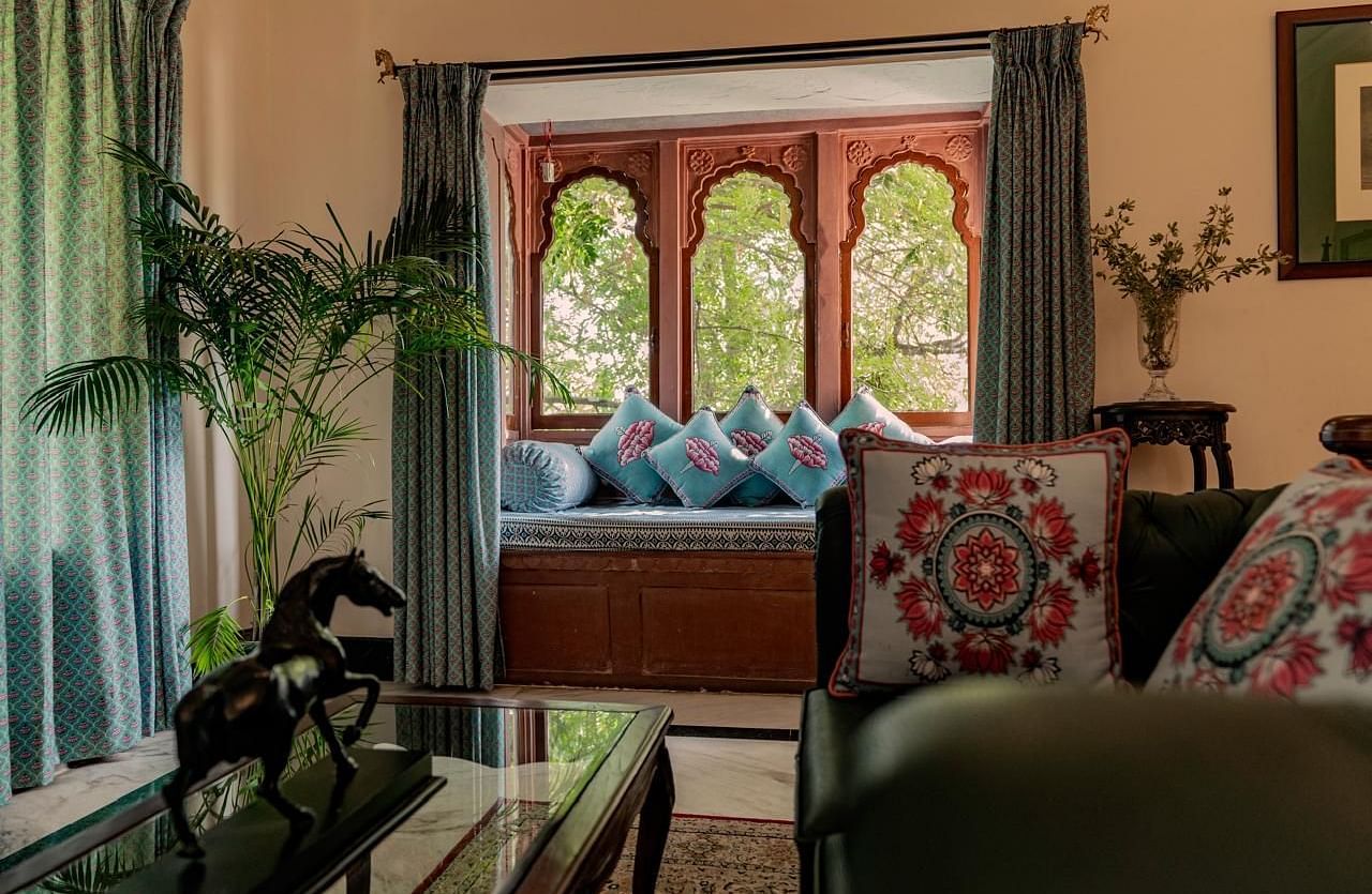 A well-lit living room with a window seating area and decorative cushions - Khas Bagh, Jaipur