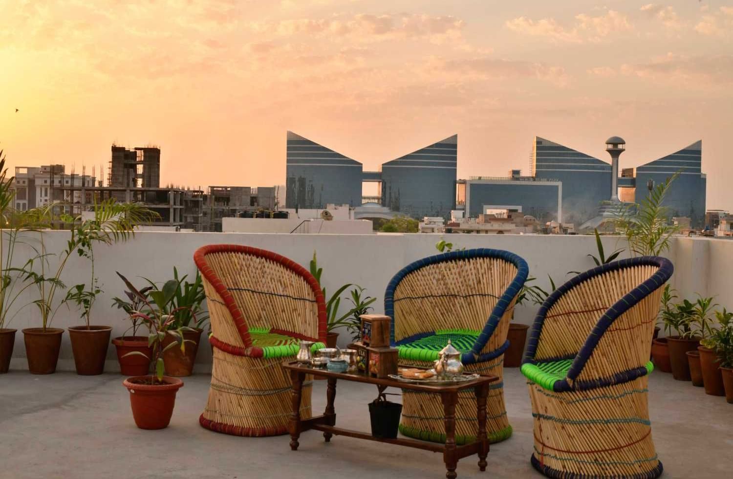 Cosy rooftop view with seating with cane chairs and a table at Jaypore360 Homestay.