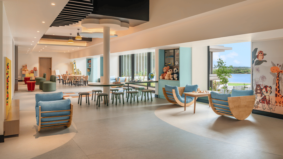 Kids' club lounge area with curved seating and bright ceiling accents at The Residency Signature Madurai.