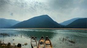 View of boats in a lake with mountains in the backdrop