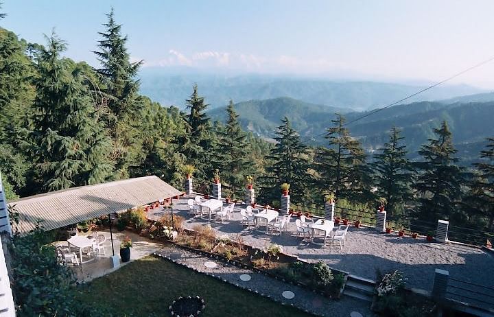 View from hotel overlooking mountains and lush greenery.