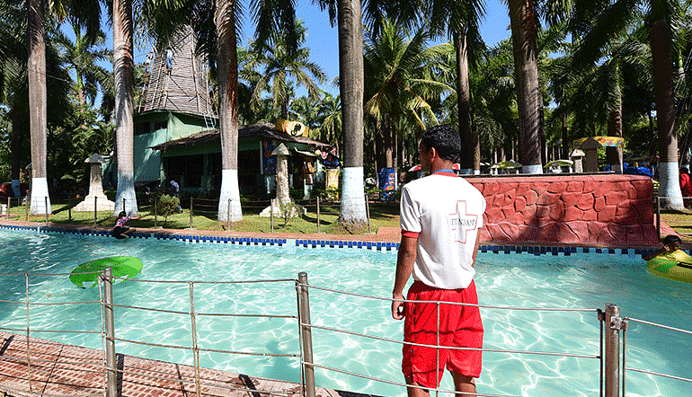 a life guard standing by a pool of water during daytime at our water park
