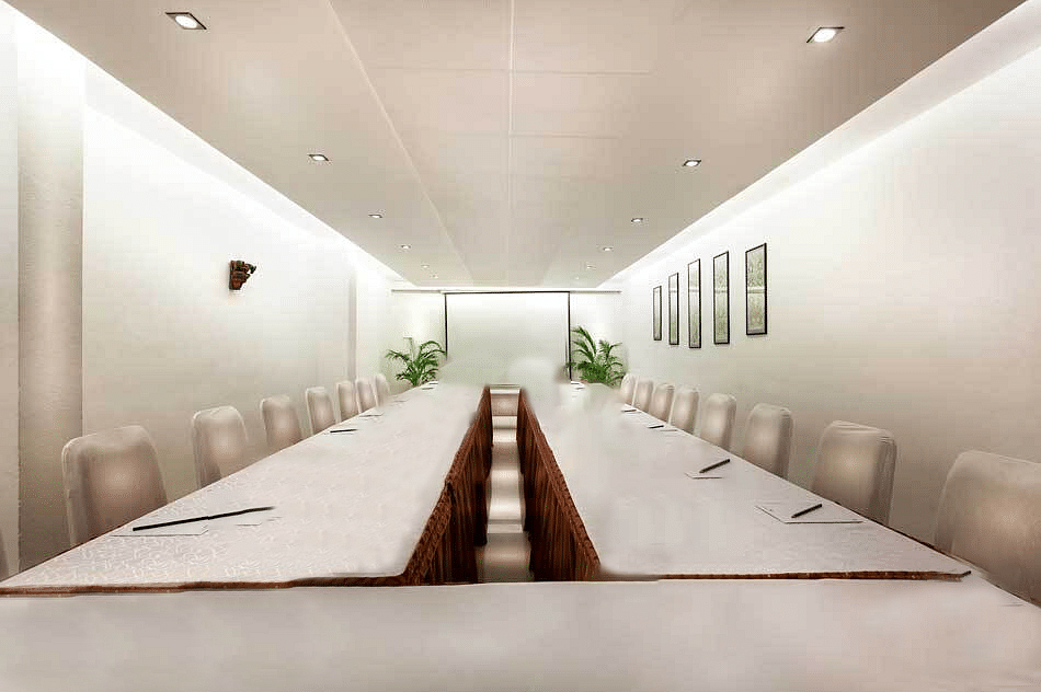 An image of a board room with long tables arranged in a U-shape setting
