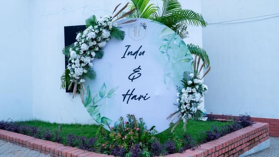 White floral welcome board with names surrounded by greenery at Ilara Hotels & Spa, OMR, Chennai
