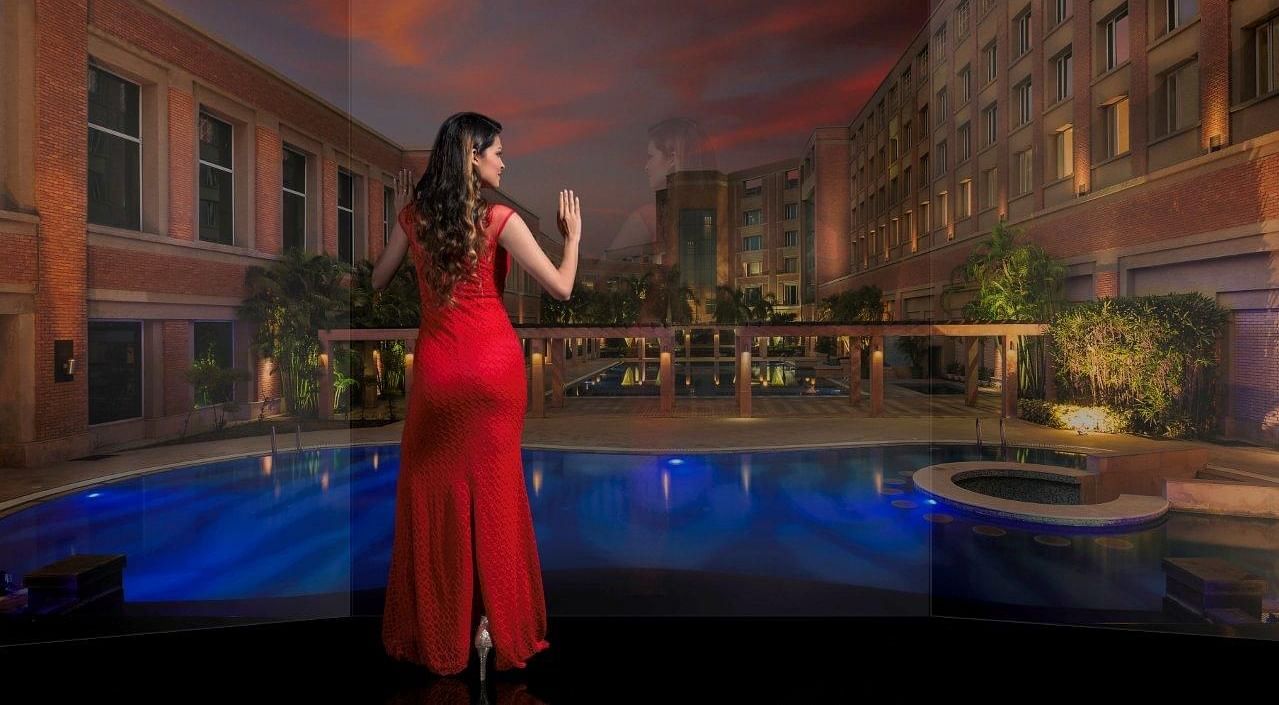 A photo shoot of a woman looking at a swimming pool at Nirvana Luxury Hotel, Ludhiana.