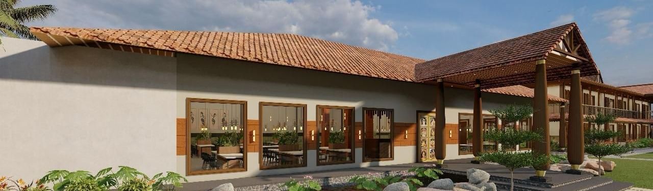 Exterior side view of a resort building with a lawn and garden | Ayana Resorts & Convention, Hyderabad