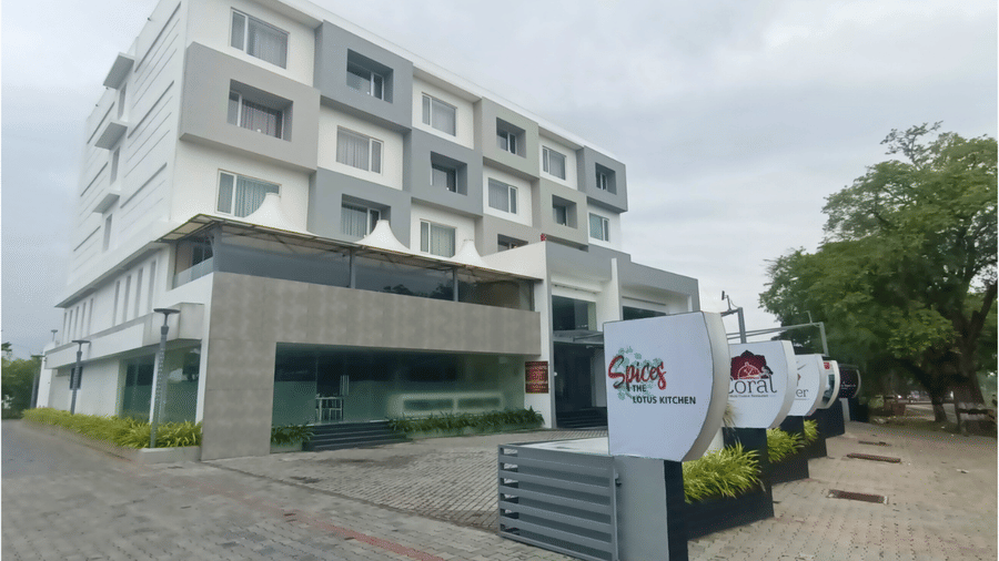 Facade of of the hotel at day featuring a multi-storey building with a parking space | Regency Palani by GRT Hotels