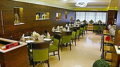 Image of dining space with tables and chairs at The Oriental Residency