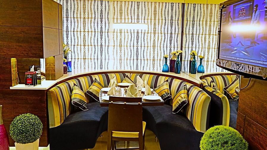 Image of a dining corner with sofas and plants on the side  at The Oriental Residency