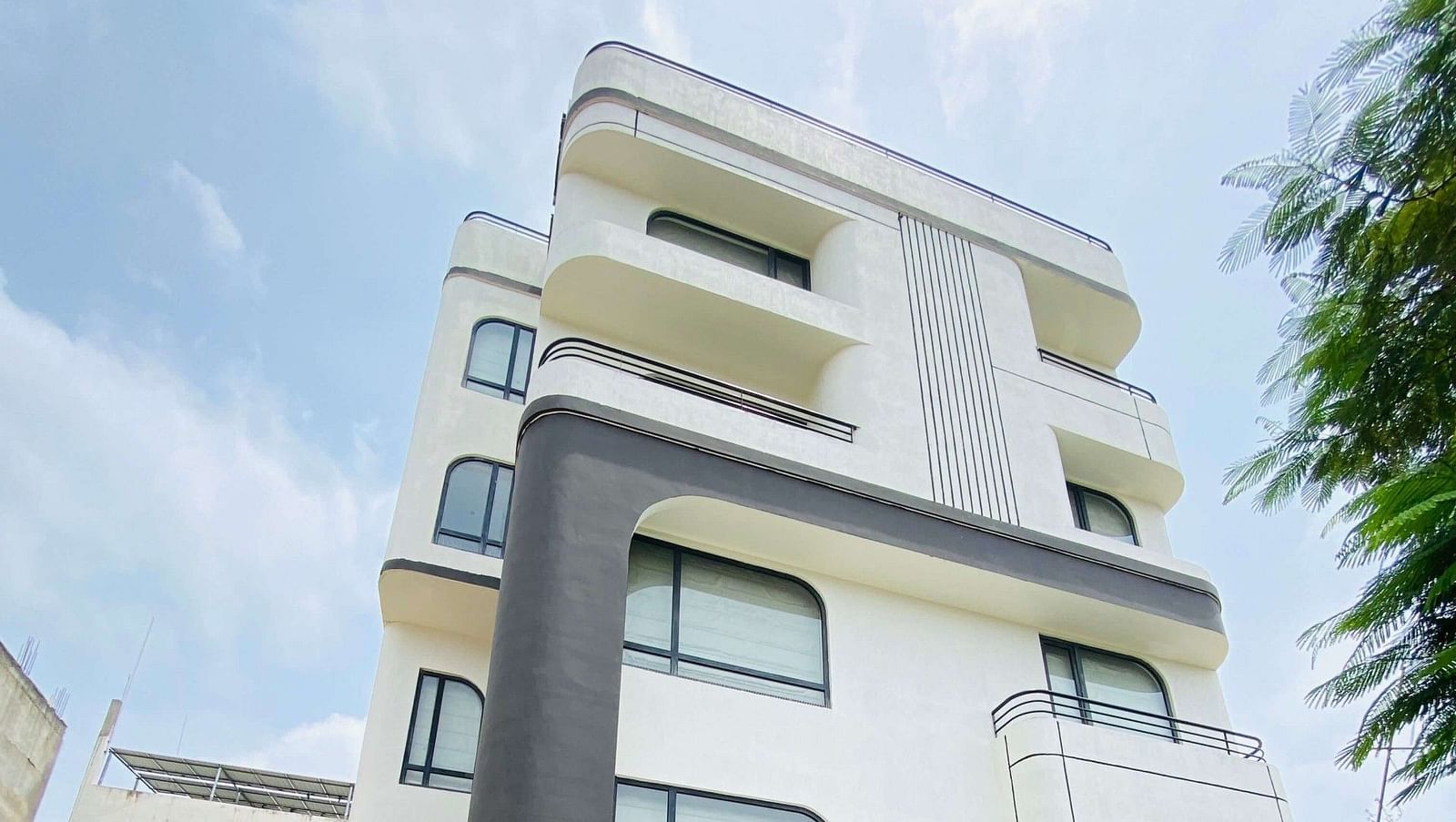 Low-angle view of Indie Stays, Jaipur, showcasing its striking facade against the open sky.