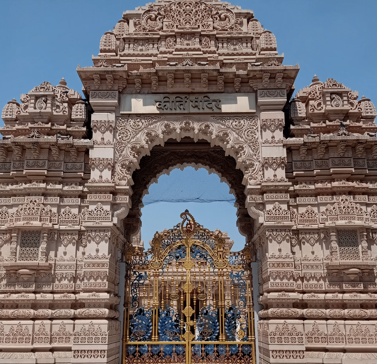 Getway of Keerti Temple featuring ornated gate and carvings on the wall