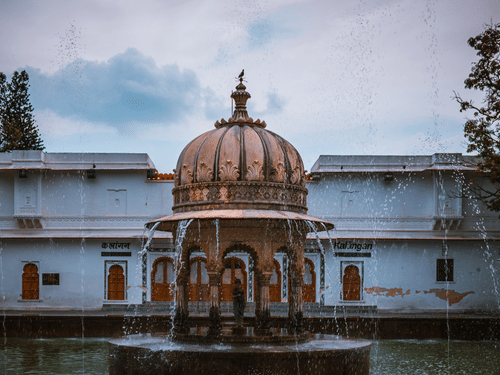 An old temple in the centre with a white building in the background