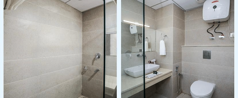 A hotel bathroom with a shower stall on the left, and a toilet and sink on the right | DLS La Serene Manali
