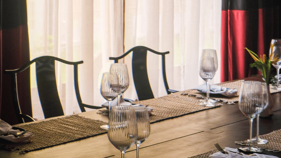 Window side dining setup with elegant seating and natural light inside Baan Kahi restaurant at Rhino and River Wildlife Retreat & Spa, Pobitora