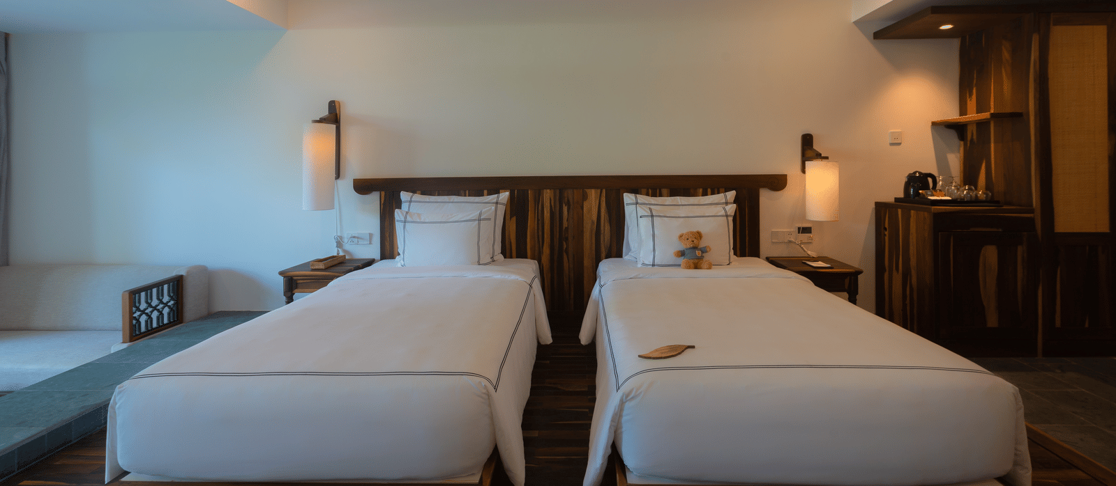 Balcony Room at Alibu Resort Nha Trang with twin beds, seating area, and outdoor access through glass doors, offering views of garden or ocean.