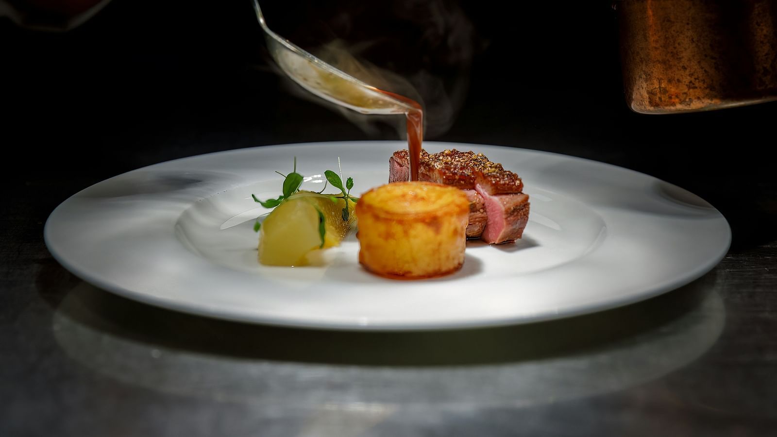A close up shot of a chef plating a dish with last minute adjustments.