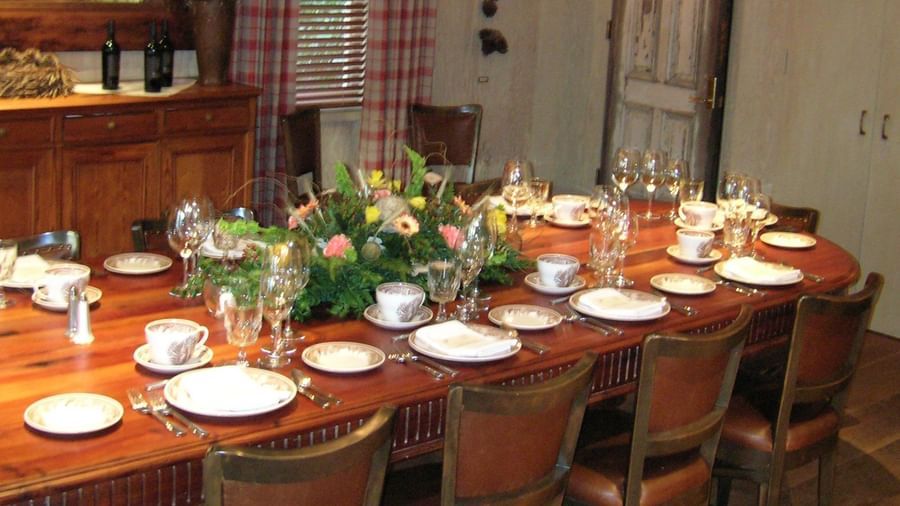 A view of Meeting room Dinner table at Tallman hotel with wooden flooring and table covered with neatly placed cutlery.