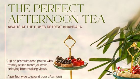 Afternoon tea setup with elegant teapots, cups, and a three-tier stand filled with colorful macarons, pastries, and savory treats at The Dukes Retreat Khandala