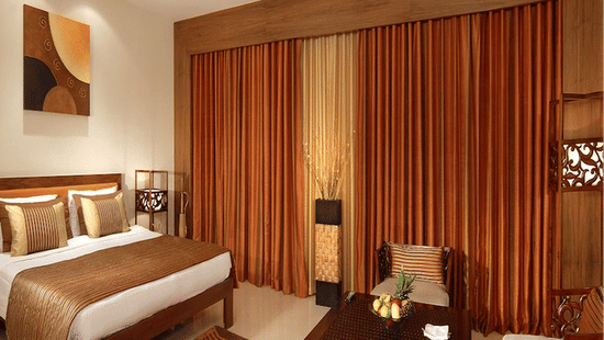 Hotel room interior with classic furniture arrangement and warm lighting.