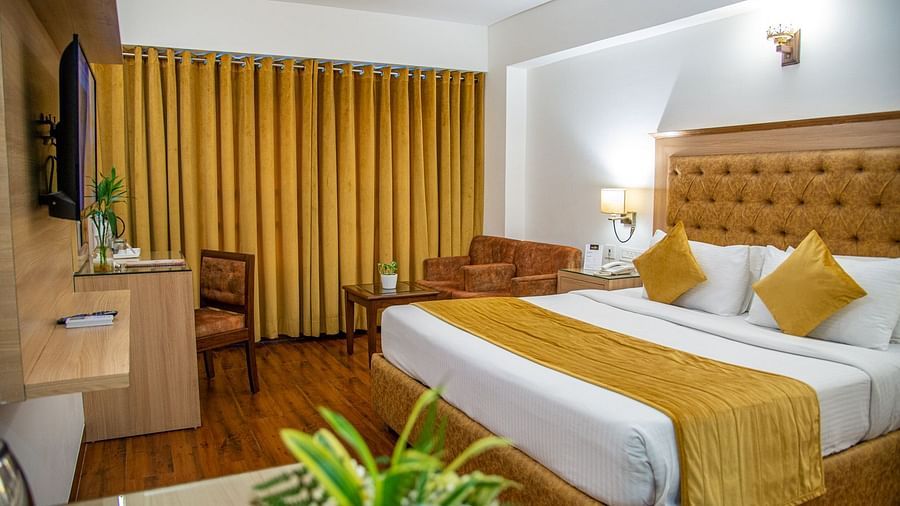 A side view of a room with a bed and TV | Sun Park Hotel & Banquet, Chandigarh - Zirakpur