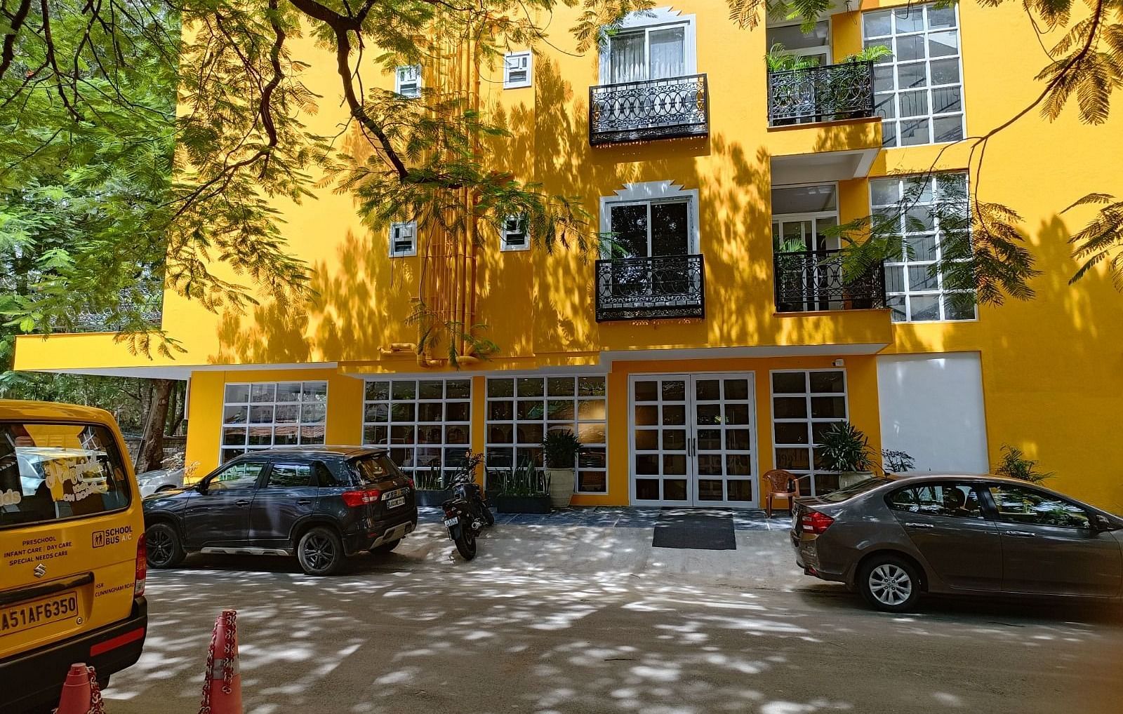 facade image of Astra Hotels and Suites in Koramangala with a bright yellow coloured exterior and beautiful windows