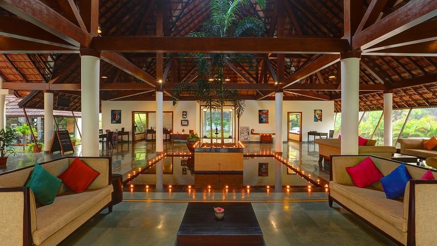 Lobby couches with lighted lamps on the floor - Rhythm Kumarakom