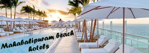 A beachside lounge area at Hotel Mamallaa Heritage, Mahabalipuram, with a pool, multiple white sunbeds, umbrellas, and palm trees with text ‘Mahabalipuram Beach Hotels’ in the image.