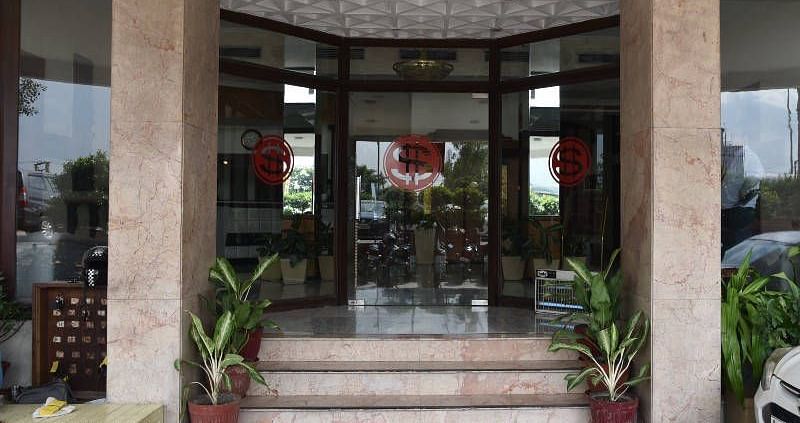 Several steps lined up with potted plants leading to the entrance of Hotel Gold, Panipat.