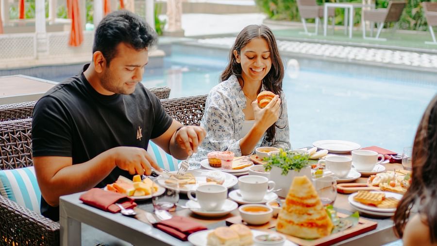 A couple enjoying their breakfast beside the pool area at Crescent Spa & Resort, Indore