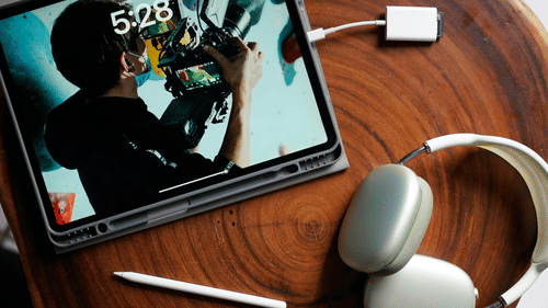 An image of a digital tablet along with a headphone laid on a table