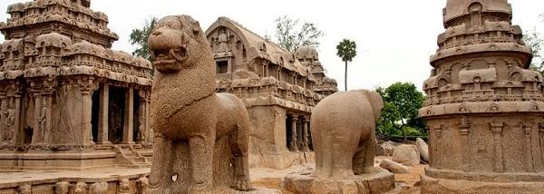 A rock-cut lion sculpture and temple structures with carvings and another sculpture, near Hotel Mamallaa Heritage, Mahabalipuram.