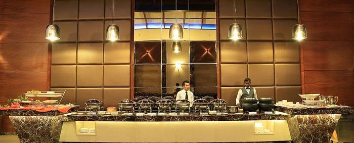 A live buffet station with chefs in action, offering a wide selection of gourmet dishes in an elegant setting. - Dhanalakshmi Srinivasan Hotels, Perambalur