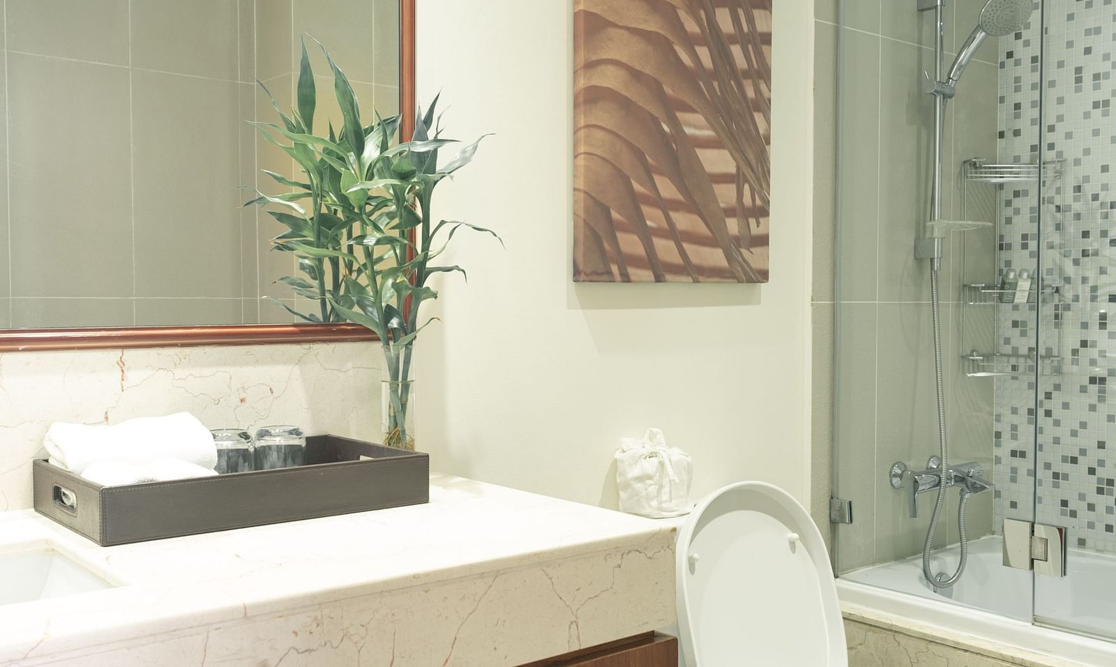 A bathroom with a sink, a mirror, and a toilet | Two-bedroom Suite | Central Mansions, Phnom Penh