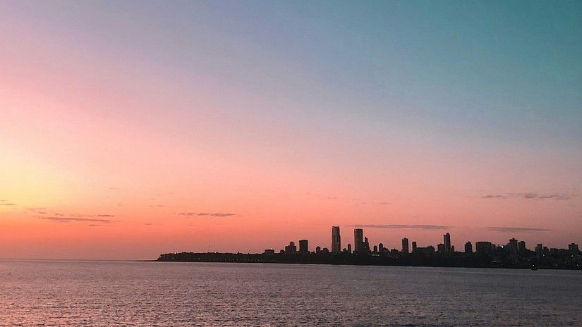 a far out view of marine drive with the sun setting on the side offering different hues in the sky