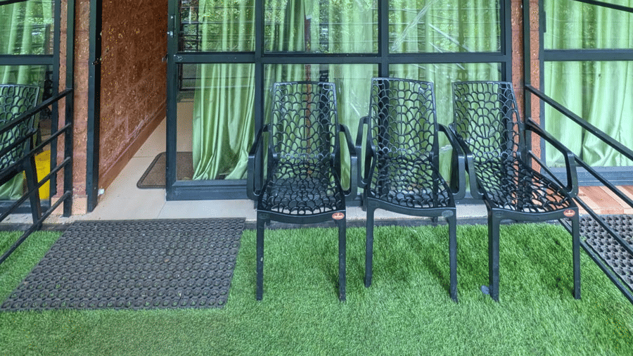 Private balcony with green surroundings and outdoor seating at Holistic Eco-Resort, Kannur.