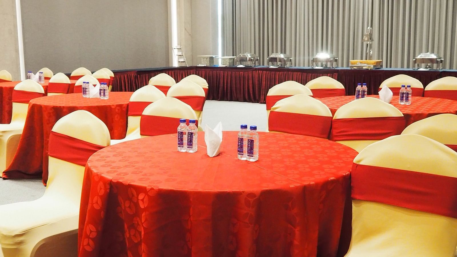 A close-up of a round table with red cloth and chairs in a hall - Club Charholi, Pune 