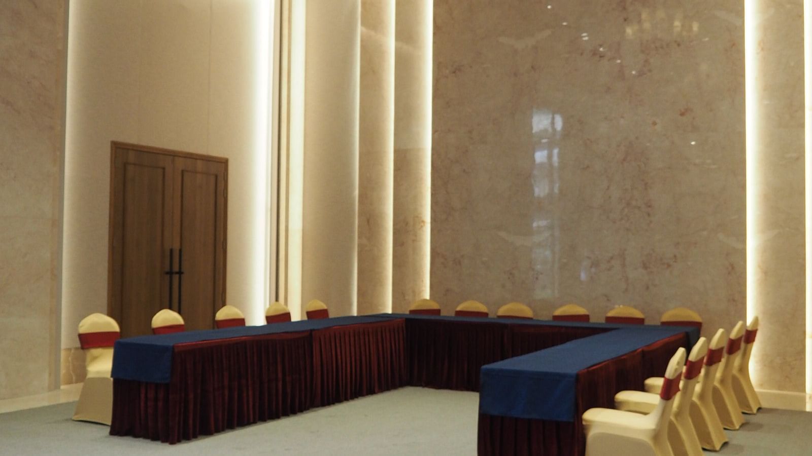 A U-shaped table arrangement in a modern, brightly lit conference space - Club Charholi, Pune 