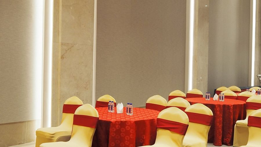 A close-up of a round table with chairs in a bright, modern hall - Club Charholi, Pune 