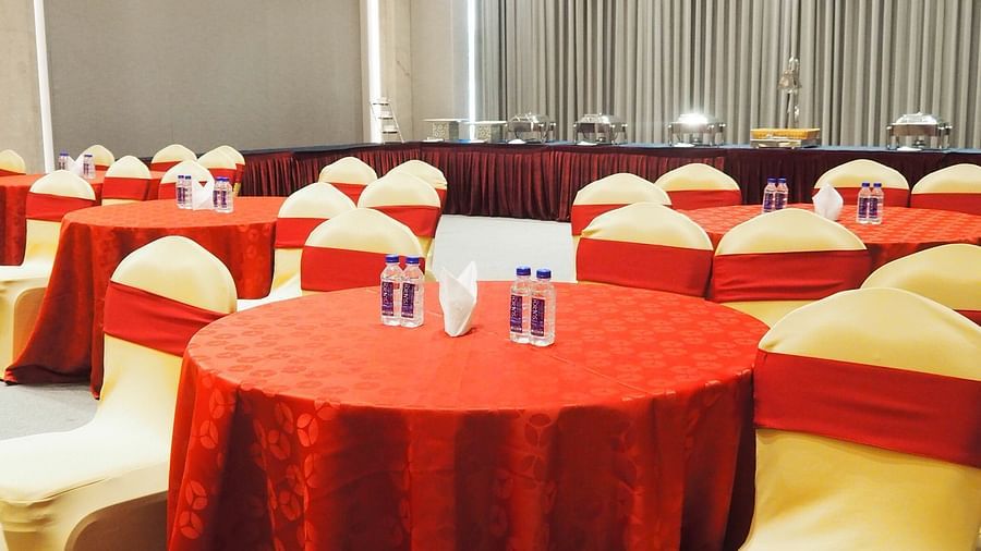 A close-up of a round table with red cloth and chairs in a hall - Club Charholi, Pune 