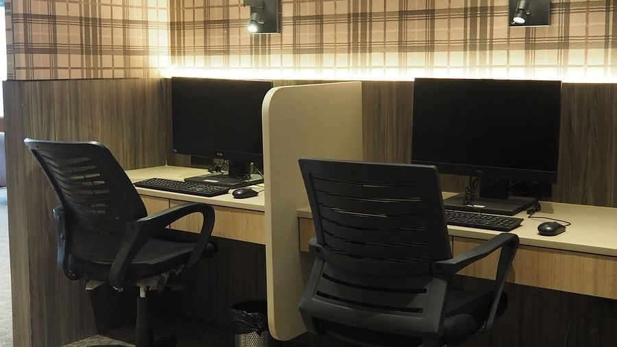 A small office space with two desks, chairs and a computer placed on the table - Club Charholi, Pune 