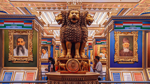 Ornate royal interior featuring a bronze statue, colourful frescoes, and intricate Rajasthani detailing.