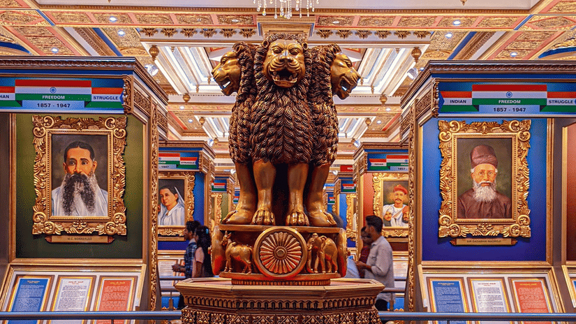 Ornate royal interior featuring a bronze statue, colourful frescoes, and intricate Rajasthani detailing.