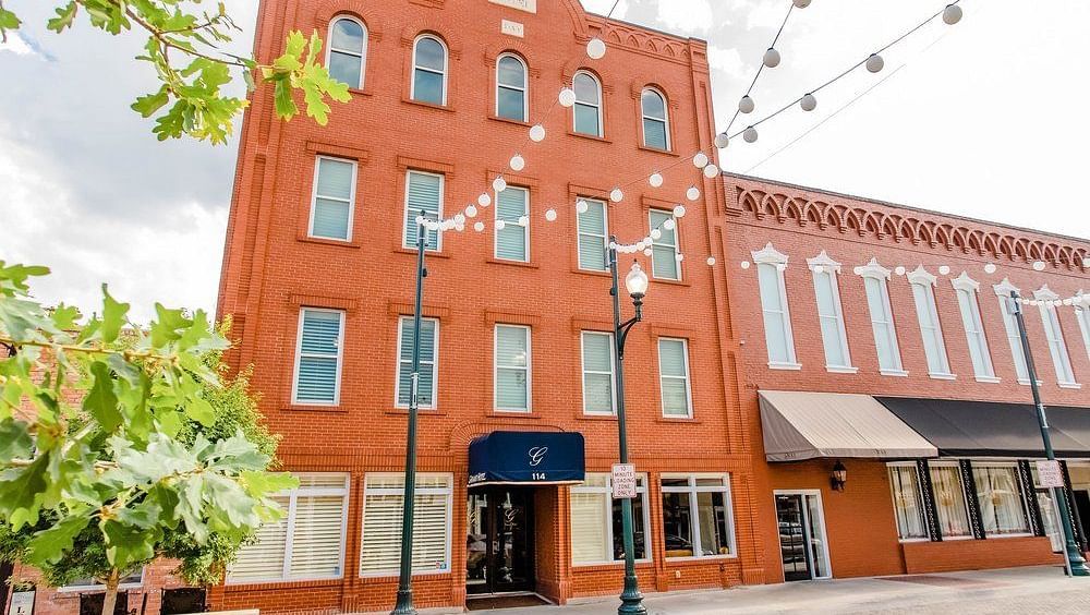  A photograph of a red-brick building with a modern design and charming architectural features, representing a historical landmark.