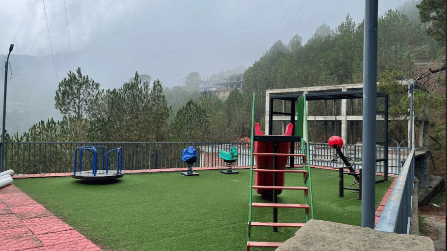 Spacious open kids play area with slides, swings, and other outdoor games, in a mist covered atmosphere at Claret Inn, Dalhousie.