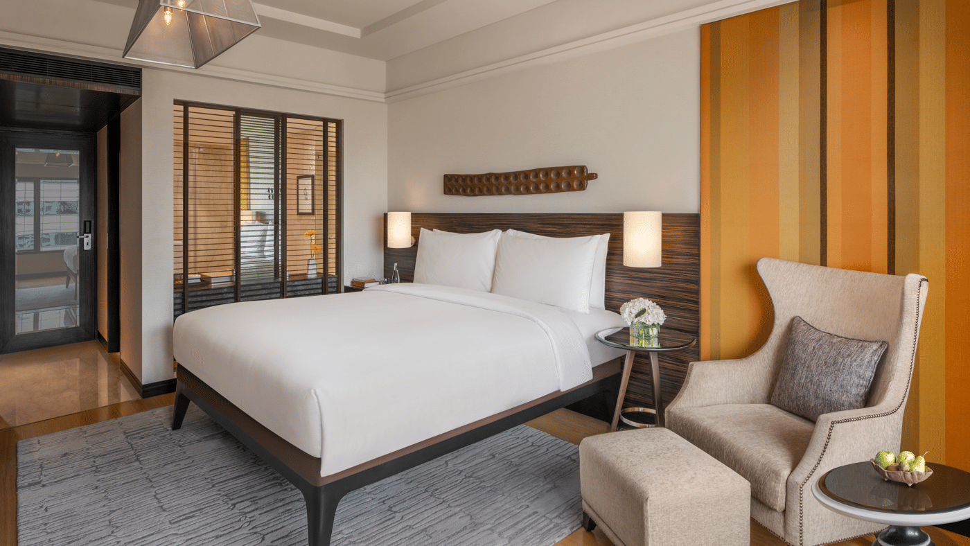 Bedroom with double bed, armchair, and side table at The Raintree, St. Mary’s Road.