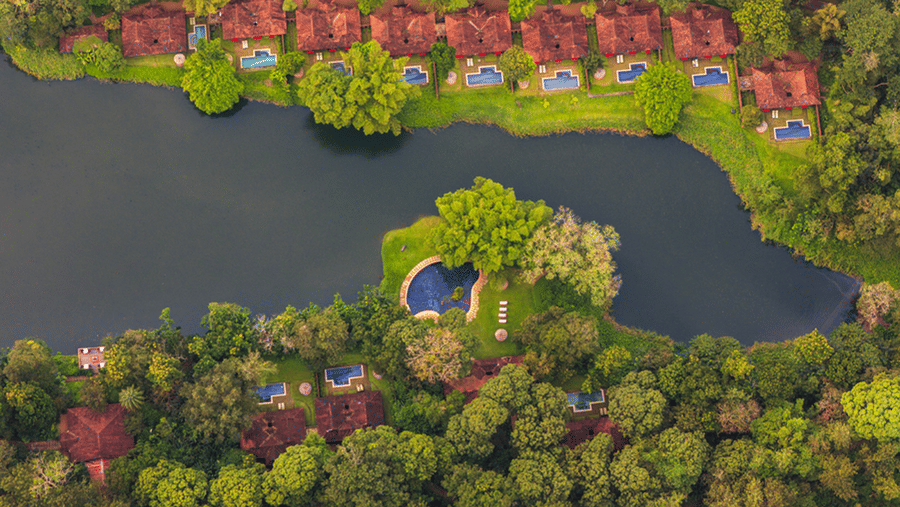 Aerial view of the full Evolve Back Coorg resort layout with lake and red-roofed villas