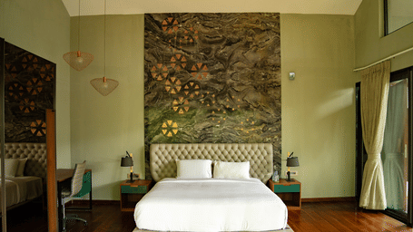 A modern bedroom featuring a patterned headboard, white linens, and large windows at Stanley Revelation.