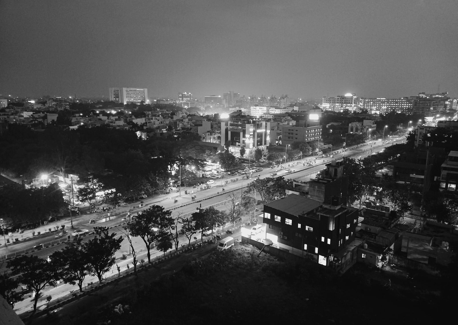 A grayscale aerial view of Indore at night with the lights on in the streets.