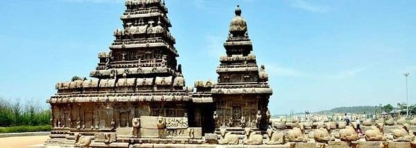 An ancient stone temple with 2 carved shrines and towers, with other carved structures, near Hotel Mamallaa Heritage, Mahabalipuram.