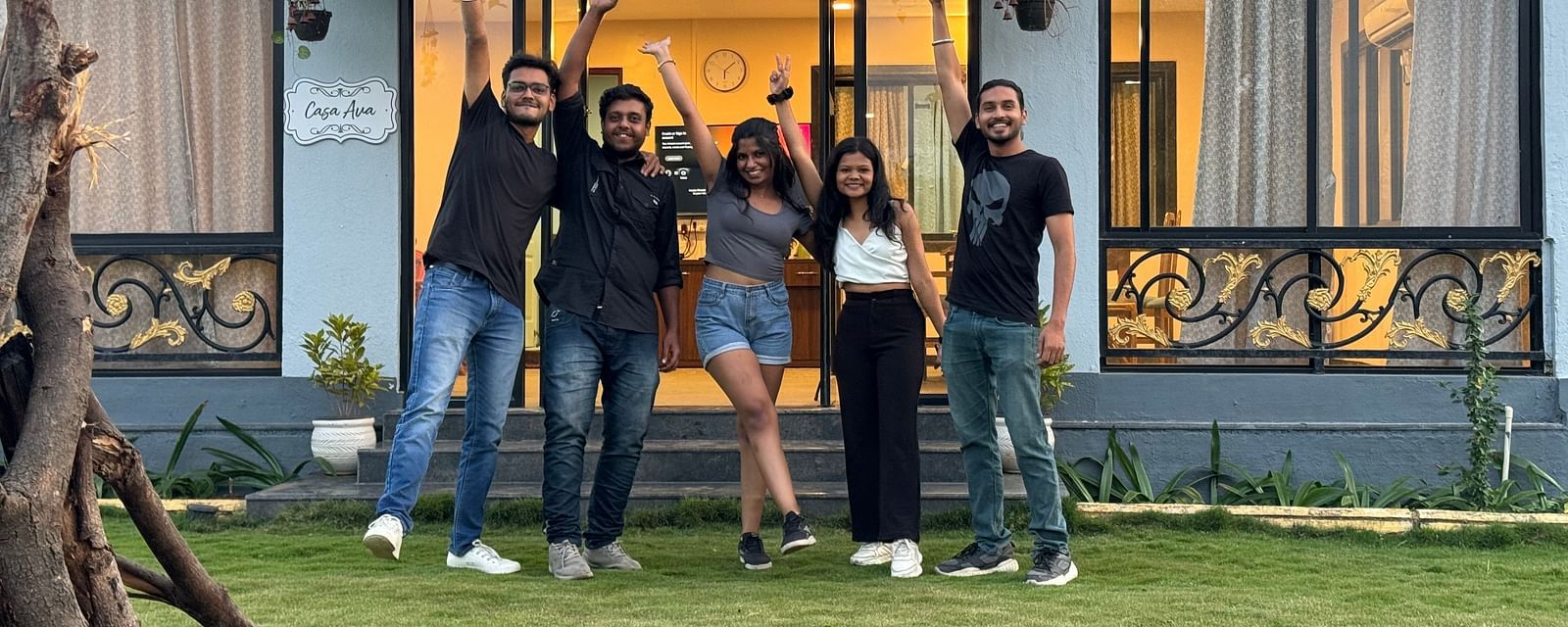 Group of friends posing joyfully in front of a hostel at sunset | Diamond Parks, Pune 